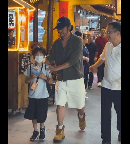 搜狐娱乐讯 近日,网友偶遇吴京带小儿子南宁吃烧烤。吴京穿开领衬衫白色短裤,头戴鸭舌帽扎小辫,随性松弛。