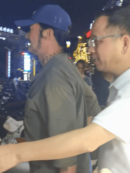 吴京头戴鸭舌帽被护送离开。