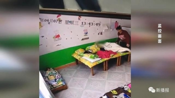 男孩在幼儿园午睡 被老师把腿搭身上