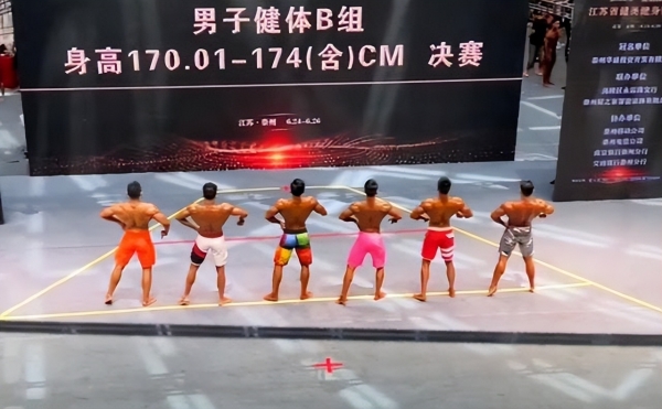 商场举行健美比赛，选手都是肌肉男，阿姨驻足观看笑得呲牙咧嘴