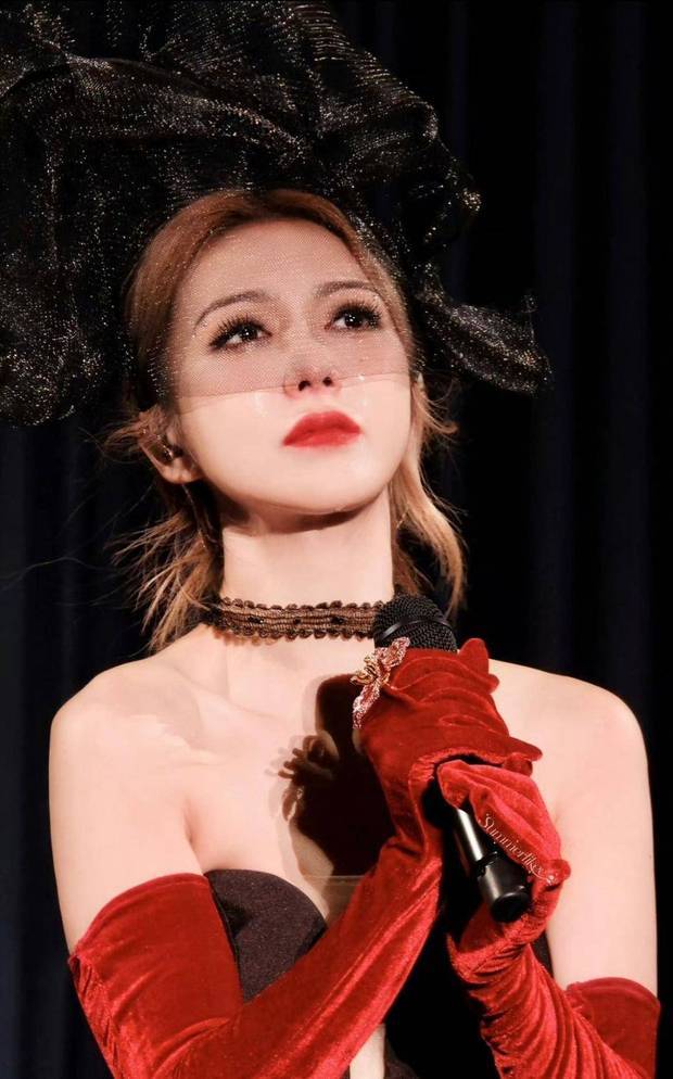 薛凯琪戴黑色网纱帽与蕾丝 choker，配红色长手套，妆容艳丽，尽显复古华丽。