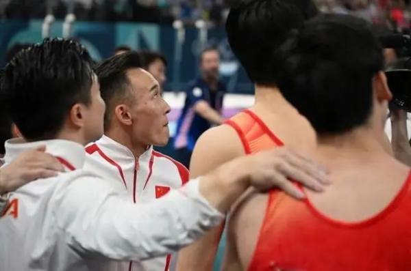 （中国队选手肖若腾(左二)与队友查看成绩。新华社记者 刘大伟 摄）