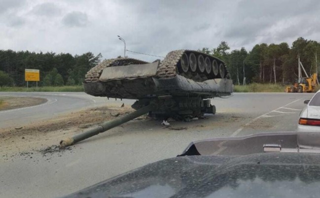 俄军主战坦克在公路上翻覆 险些砸到路过汽车